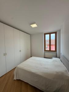 Un dormitorio blanco con una cama grande y una ventana. en IseoParadise, en Pisogne