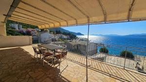a balcony with a table and chairs and the ocean at Apartmani Igrane 3 in Igrane
