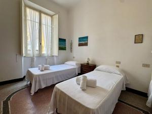 a room with two beds and a window at Hostdomus - Cherry House in Alassio