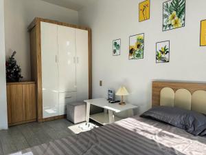 Katka Riverside Homestay Hai Phong في An Dương: غرفة نوم مع سرير ومكتب وخزانة