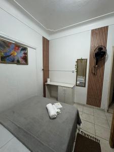 a room with a bed and a mirror in it at Pousada Mãe Linda in Aparecida