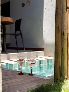 ein Paar Weingläser neben einem Pool in der Unterkunft Aconchego de Milagres Casa2 750m praia do Riacho. in São Miguel dos Milagres