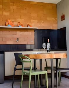 eine Küche mit einem Tisch mit 2 Stühlen und einem Glas Wein in der Unterkunft Aconchego de Milagres Casa2 750m praia do Riacho. in São Miguel dos Milagres + 42 Fotos