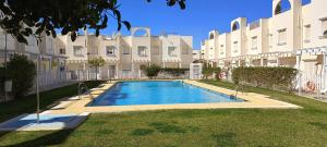 a swimming pool in front of a large building at Dúplex en Vera a 200m de la Playa in Vera