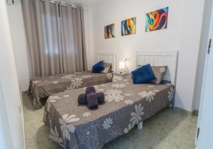 a bedroom with two beds with blue pillows at Dúplex en Vera a 200m de la Playa in Vera +20 photos