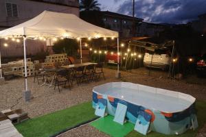 ein Pool im Garten mit einem Zelt, einem Tisch und Stühlen in der Unterkunft Lost in Memory in Sanxing Township