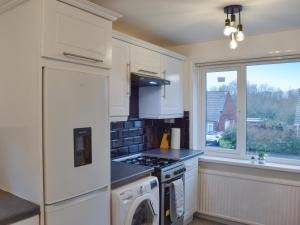 a kitchen with a stove top oven next to a window at West Park House in Penwortham