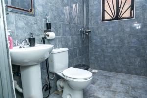 a bathroom with a toilet and a sink at KiNaO in Bulindo +15 photos