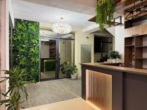 an office lobby with a green wall and plants at Generator Tashkent Hostel in Tashkent