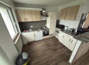 a small kitchen with white cabinets and wooden floors at Ferienwohnung Saika in Diefflen