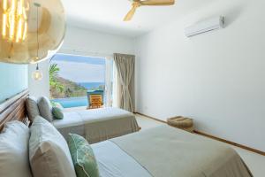 a bedroom with two beds and a view of the ocean at Stylish ocean view Villa Blume at Hermosa Hills in Playa hermosa +44 photos