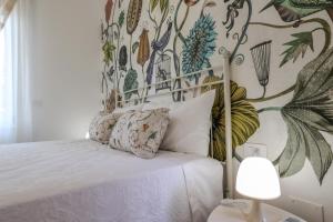 Apartments Le Rondini 3 في كاردانو آل كامبو: غرفة نوم بسرير مع جدار ازهار