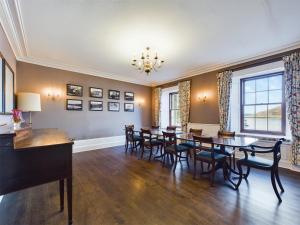 a dining room with a long table and chairs at Voe House in Voe