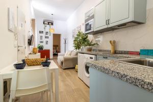 eine Küche und ein Wohnzimmer mit weißen Schränken und einem Tisch in der Unterkunft Apartamento Santa Clara 3 in Jerez de la Frontera