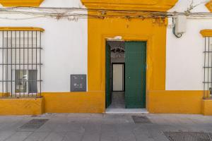 ein gelbes und grünes Gebäude mit grüner Tür in der Unterkunft Apartamento Santa Clara 3 in Jerez de la Frontera
