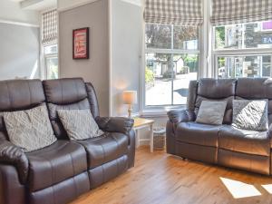 a living room with two leather couches and a table at Woodys in Windermere