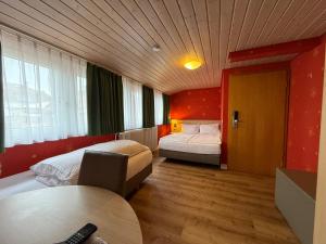 a hotel room with two beds and a table at Hotel Hafner Stuttgart in Stuttgart