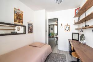 una camera da letto con un letto e una scrivania di Boho Zen - T3 calme avec parking en ville a Montpellier