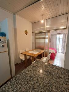 a kitchen and dining room with a table and a refrigerator at Habegger Suites Centro Reconquista in Reconquista