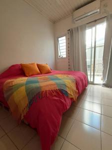 a bed with a colorful blanket in a room at Habegger Suites Centro Reconquista in Reconquista