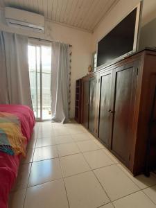 a bedroom with a bed and a flat screen tv at Habegger Suites Centro Reconquista in Reconquista