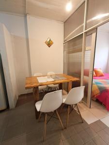 a table and chairs in a room with a bed at Habegger Suites Centro Reconquista in Reconquista +3 photos