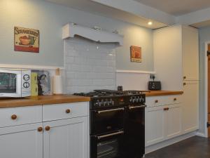 a kitchen with a black stove and a microwave at Holme Cottage in Eastry +9 photos