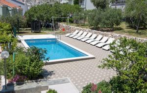 a swimming pool in a yard with lounge chairs at Stunning Home In Omis in Omiš +54 photos
