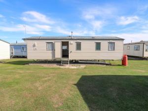 a white mobile home in a yard with a yard at Singh Leite & Luisa Family Caravan in Jaywick Sands