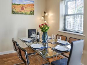 a dining room with a glass table and chairs at 1 Kirkby Cottages in Sheriff Hutton
