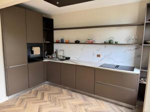 a kitchen with brown cabinets and a counter top at Bed and Breakfast Heemraadssingel in Rotterdam +7 photos