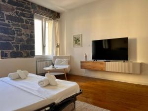 a bedroom with a tv and a bed with towels at RivApartments2 FREE private parking in Trieste