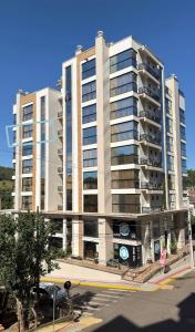 a large building with a parking lot in front of it at Apto Flor de Romã - 2 Quartos, Apto todo climatizado, à 150m do Parque Termal! in Piratuba