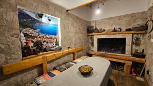 a living room with a fireplace and a table and a painting at Apartmani Igrane 3 in Igrane