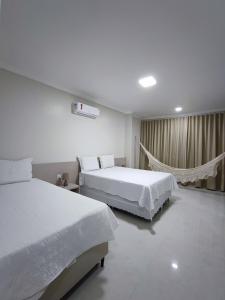 a hotel room with two beds and a window at Jurubeba Hotel de Charme in Belém