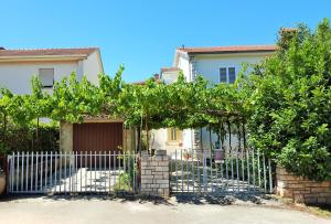 uma casa com um portão com um monte de uvas em Apartment Lavanda em Fažana