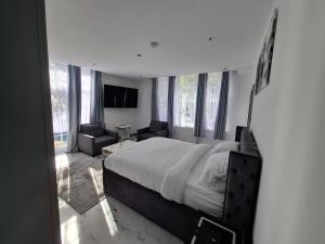 a bedroom with a large bed and a living room at Guyrock Apartments in London