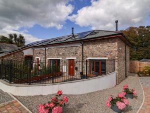 a brick house with a fence and flowers at Butterfly Days in Bideford