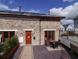 a brick house with a wooden door and a patio at Butterfly Days in Parkham