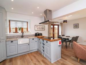 a kitchen with white cabinets and a dining room at Butterfly Days in Parkham +18 photos