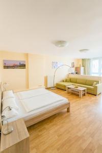 Un dormitorio grande con una cama grande y un sofá. en Apartments Atomis Hotel Düsseldorf City, en Düsseldorf