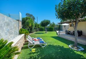 a garden with a white bench in the grass at Owl Booking Villa Rafale - 5 Min Drive to The Beach in El Port