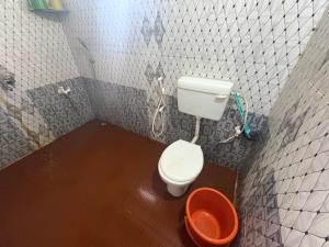 a bathroom with a toilet and a bucket in it at Coco beach front stay in Gokarn