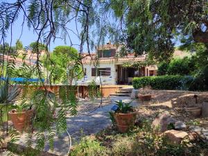 a house with a lot of plants in a yard at Villa le Clos Ferté au Lavandou in Le Lavandou