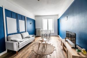 un salon avec des murs bleus et un canapé dans l'établissement Marine comfort T3 cozy city center WiFi & Netflix, au Havre