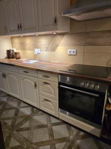 a kitchen with white cabinets and a stove top oven at Auszeit Posthausen in Machern
