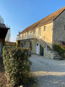 un edificio con una scala accanto a una casa di Gite du Trefoux logement le Villainois a Villaines-la-Gonais