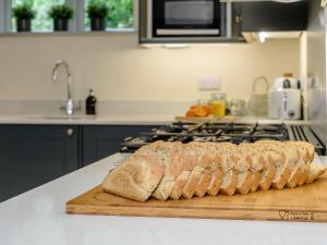 a loaf of bread on a cutting board on a kitchen counter at Bluestone Cottage in Welton le Wold