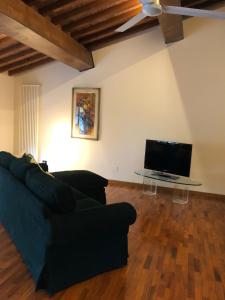 a living room with a black couch and a tv at Appartamento in villa storica: Villa Giulia in Empoli