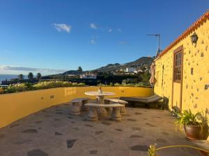 a patio with a table and benches on a building at Los Frailes in Breña Baja